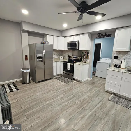 a kitchen with stainless steel appliances kitchen island granite countertop a refrigerator stove and sink
