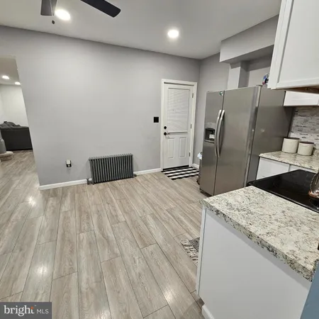 a kitchen with stainless steel appliances kitchen island granite countertop a refrigerator and a sink
