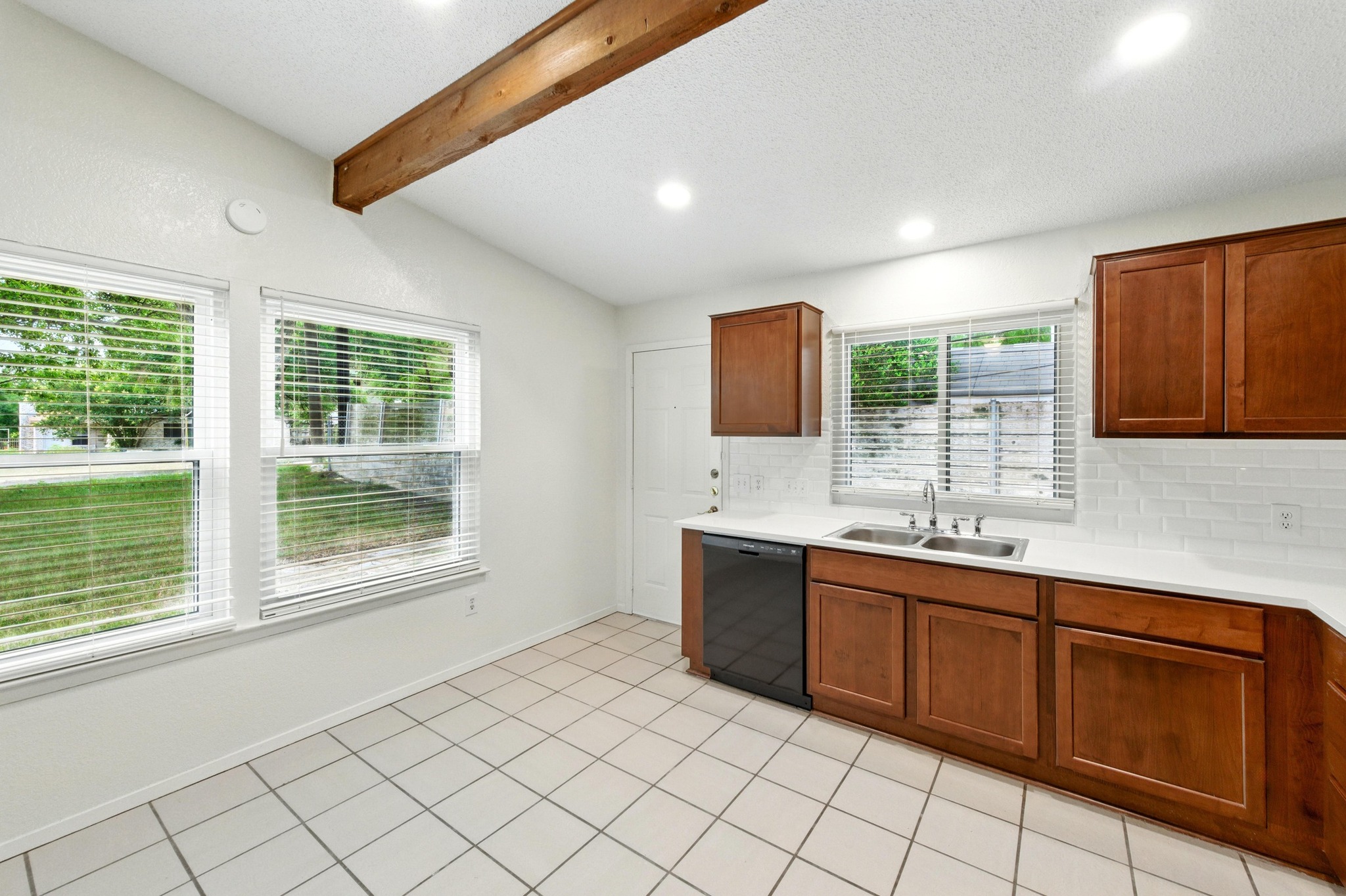 2002 Rabb Road Austin, TX 78704 - Photo 15 of 25 A well-lit eat-in kitchen with classic white tile flooring and warm wood cabinetry awaits.