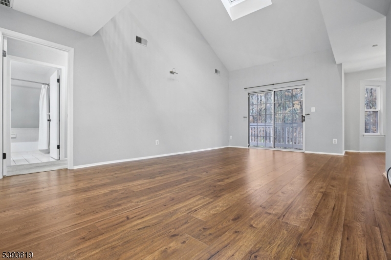66 Whisper Way East Ledgewood, NJ 07852 - Photo 6 of 38 a view of an empty room with wooden floor and a window