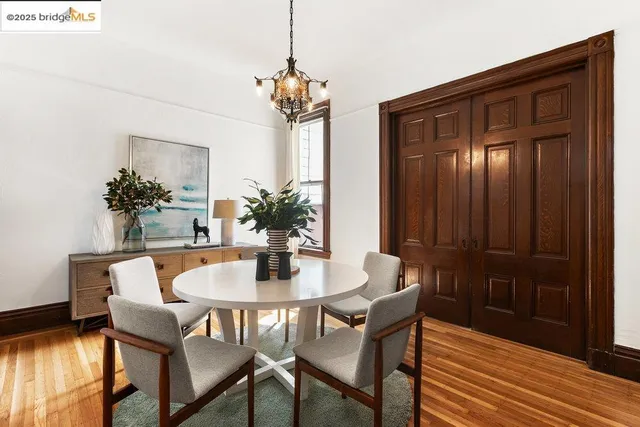 a dining room with furniture potted plants and wooden floor