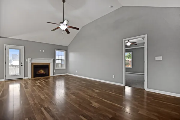 a view of empty room with wooden floor and fireplace