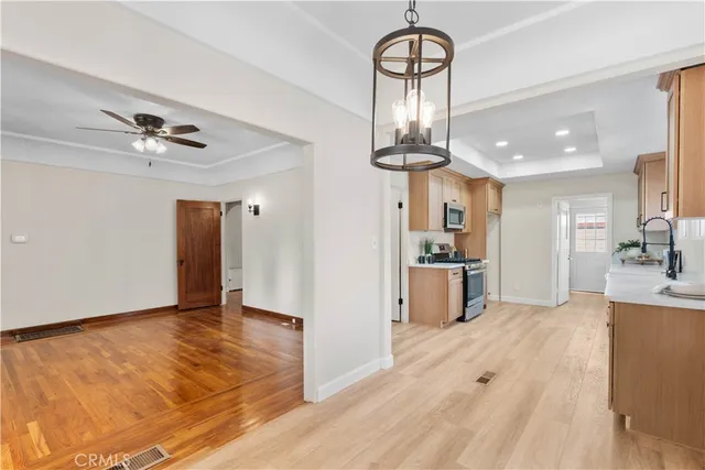 a view of large kitchen with stainless steel appliances granite countertop living room and hallway