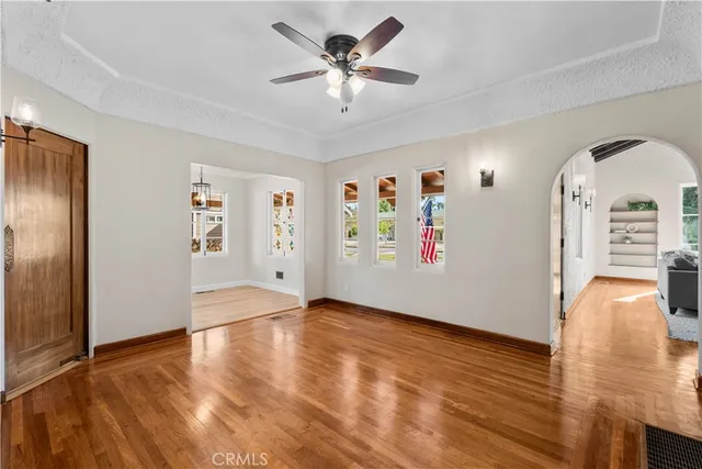 a view of an empty room with window and wooden floor