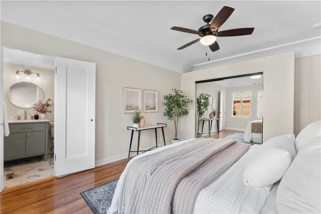 a bedroom with a large bed and wooden floor