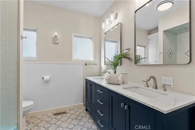a bathroom with a granite countertop sink a toilet and a mirror