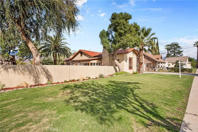 a view of a white house with a yard and potted plants