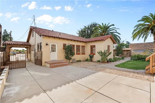 a front view of a house with a yard and potted plants