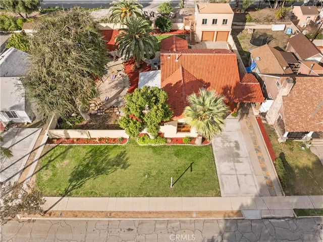 an aerial view of a house with yard and seating area