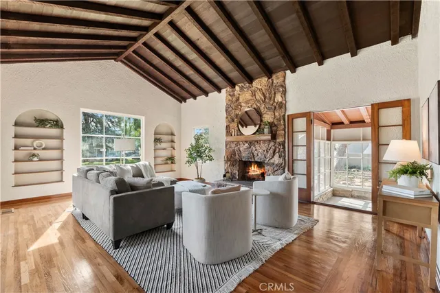a living room with furniture a fireplace and a floor to ceiling window
