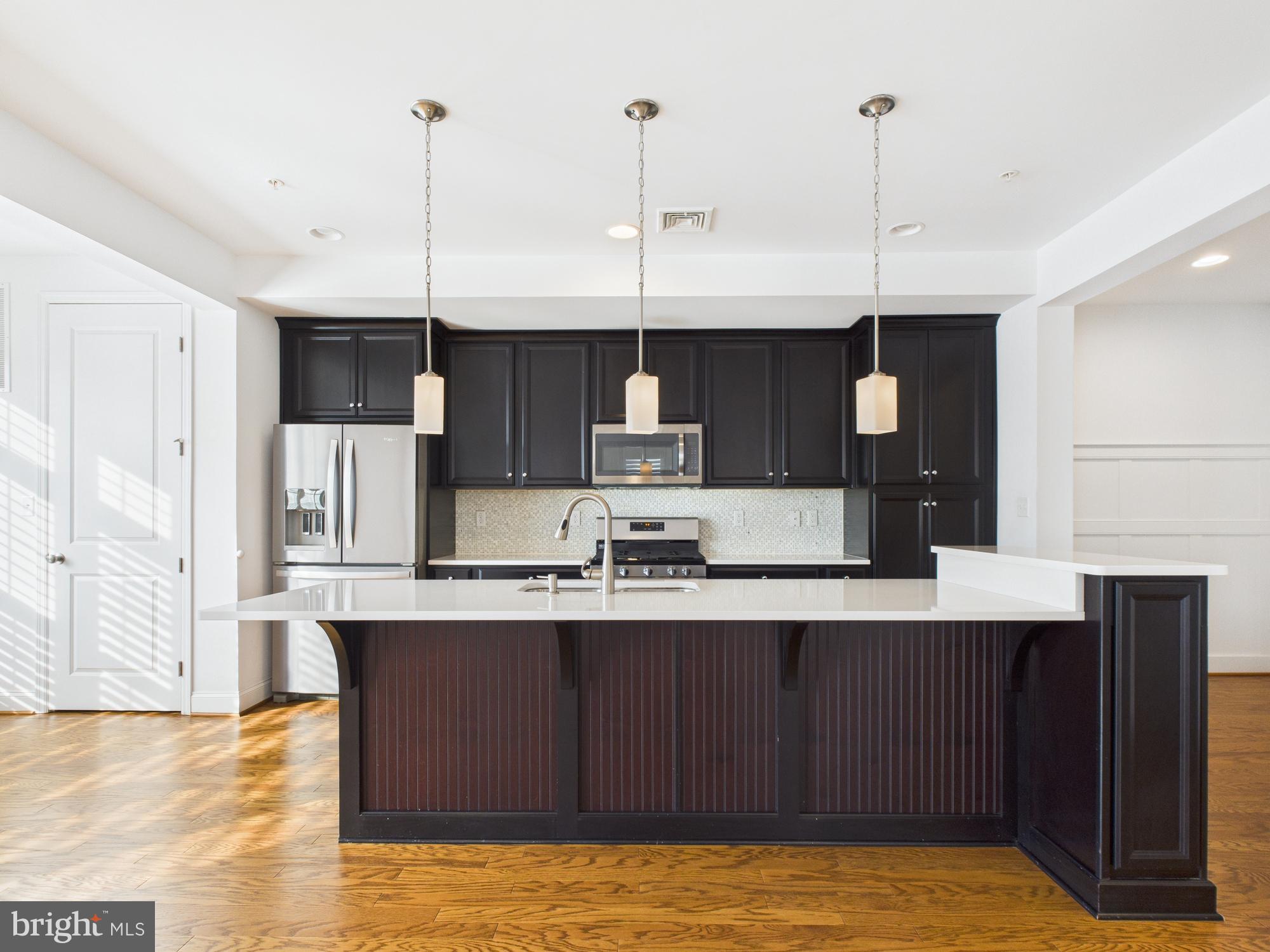 702 Mayer Place Lancaster, PA 17601 - Photo 2 of 19 a kitchen with kitchen island stainless steel appliances a sink a counter top space and cabinets