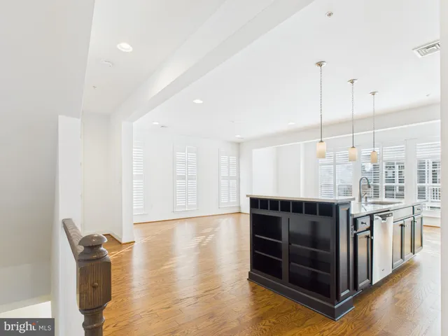 a living room with furniture a flat screen tv and kitchen view