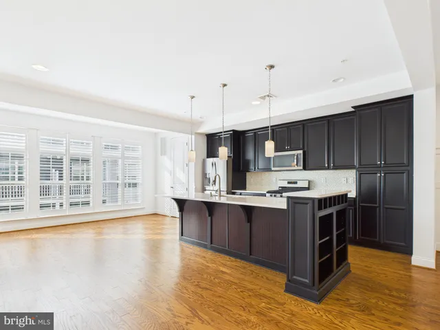 a kitchen with kitchen island granite countertop a stove and a sink