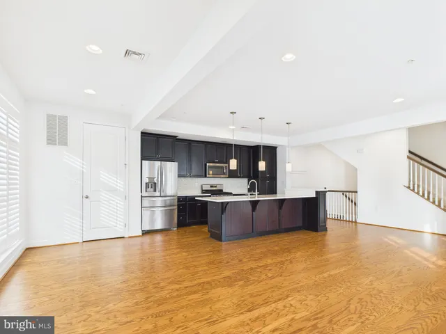 a large kitchen with stainless steel appliances granite countertop a stove and a refrigerator
