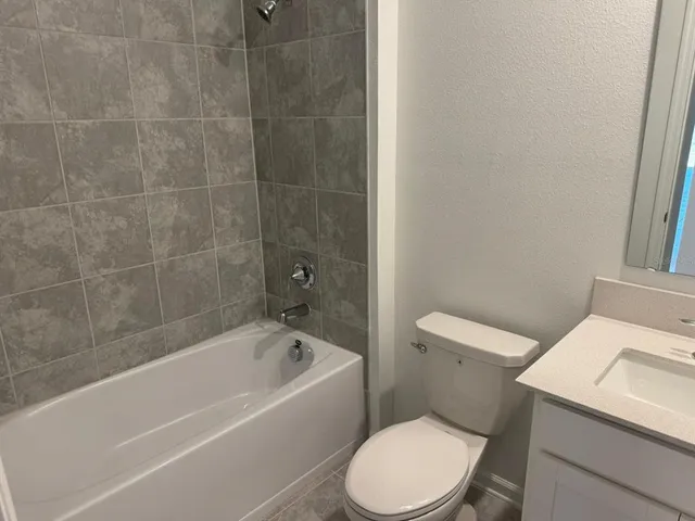 a white toilet and tub sitting next to a bathroom sink