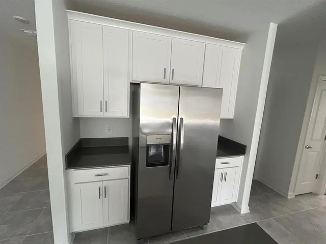 a kitchen with stainless steel appliances kitchen island a refrigerator sink and cabinets