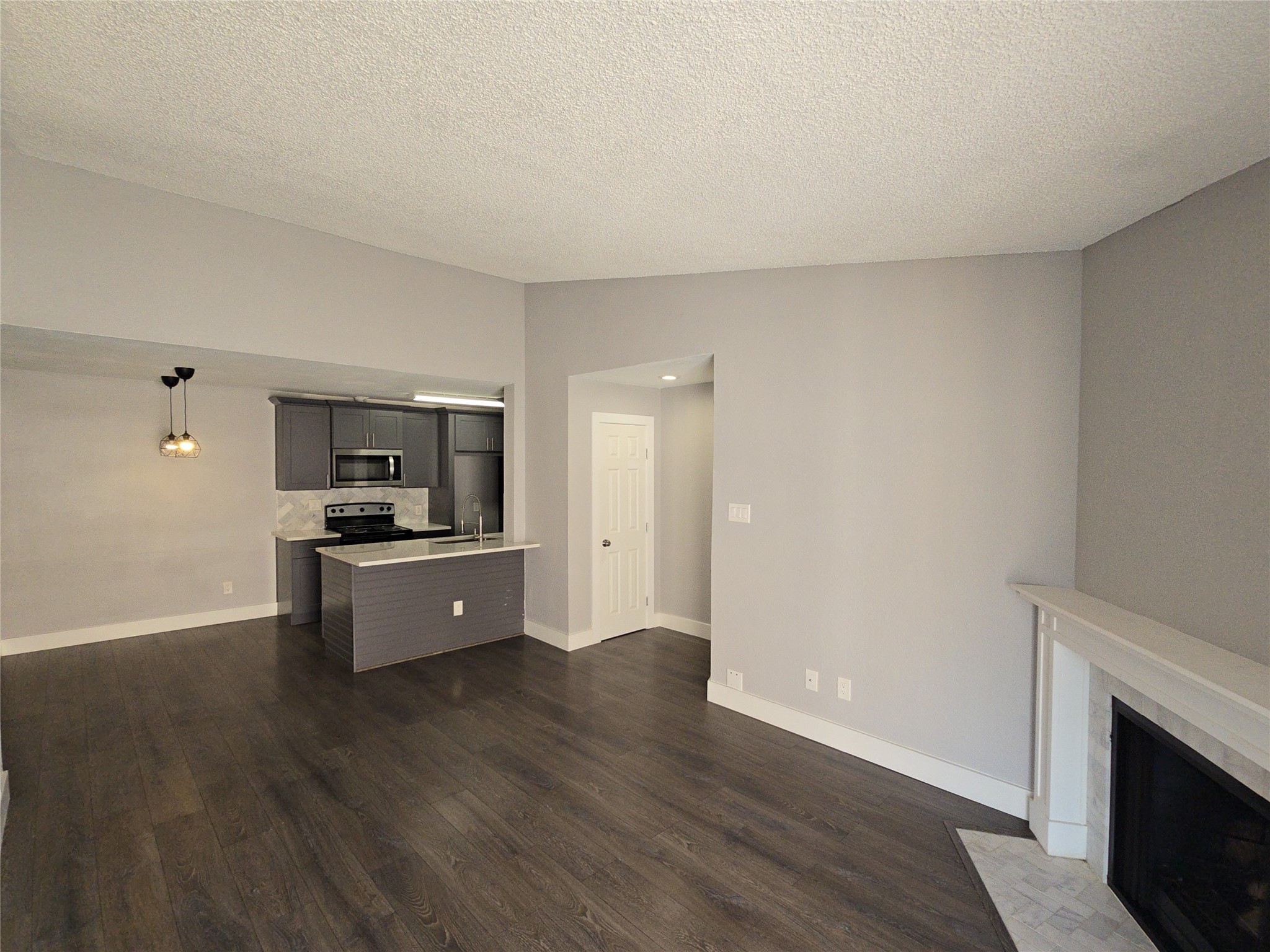 10101 South Gessner Road, Unit 708 Houston, TX 77071 - Photo 11 of 20 a large white kitchen with stainless steel appliances wooden floors and white walls