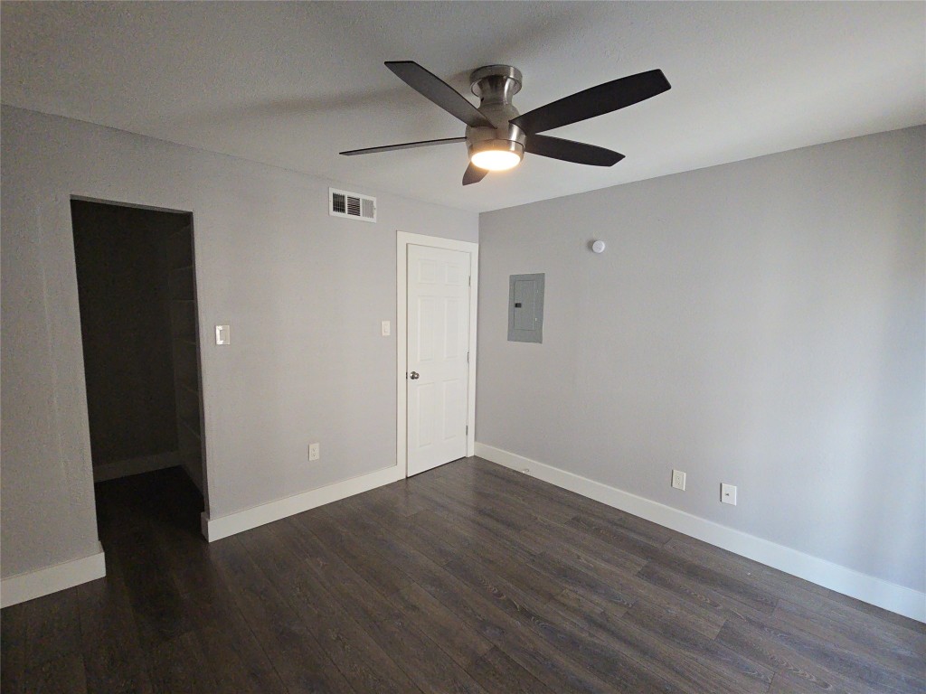 10101 South Gessner Road, Unit 708 Houston, TX 77071 - Photo 6 of 20 an empty room with wooden floor and a ceiling fan