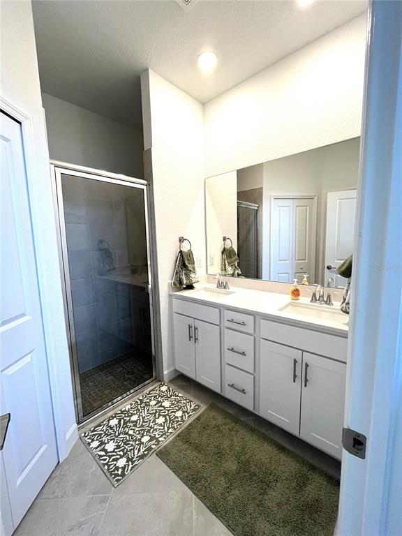 8787 St Kitts Circle Englewood, FL 34224 - Photo 11 of 29 a bathroom with a sink a toilet a shower a mirror and