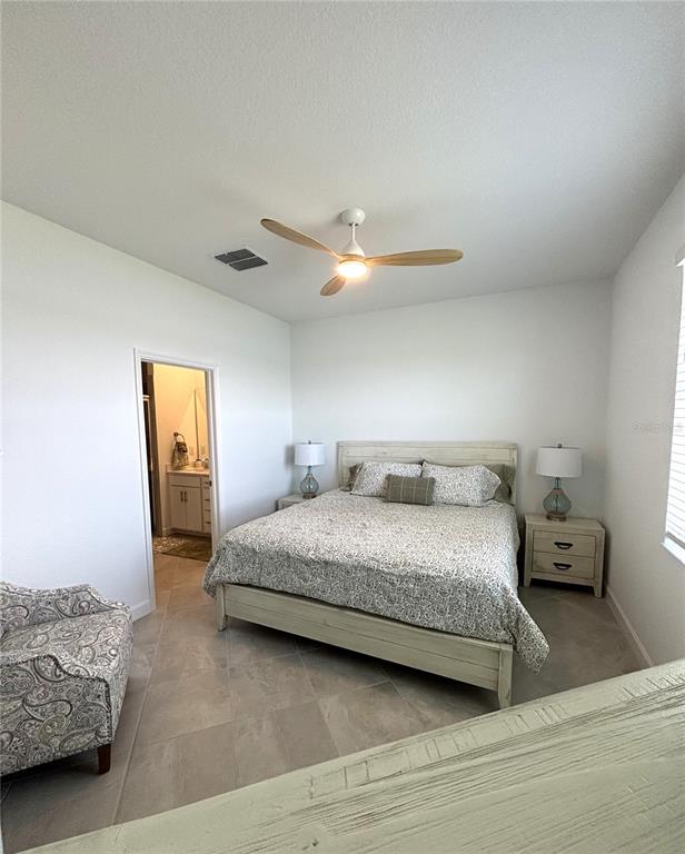 8787 St Kitts Circle Englewood, FL 34224 - Photo 12 of 29 a bedroom with a bed and a chandelier