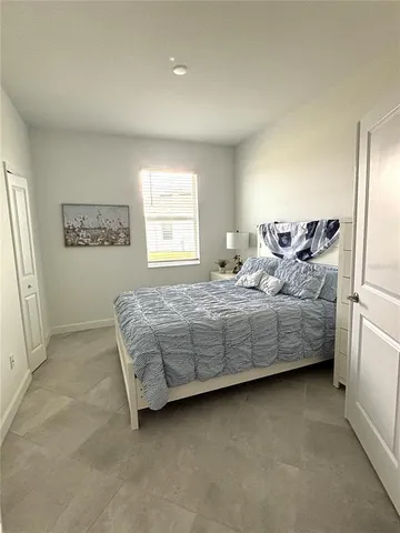 a bedroom with a bed table and window