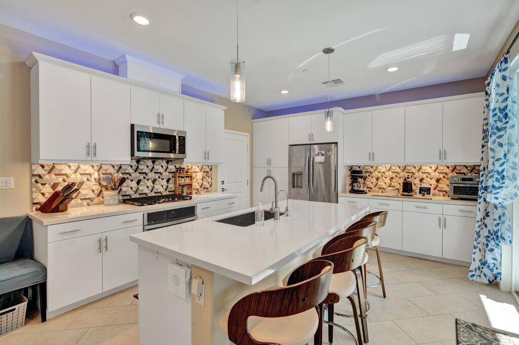 76345 Cornell Way Palm Desert, CA 92211 - Photo 1 of 47 a kitchen with a sink a stove a refrigerator and white cabinets with wooden floor