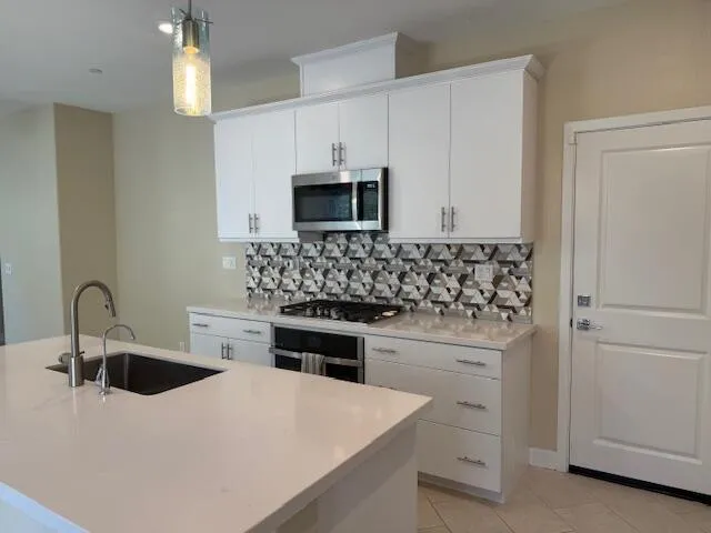 a kitchen with granite countertop white cabinets and white appliances