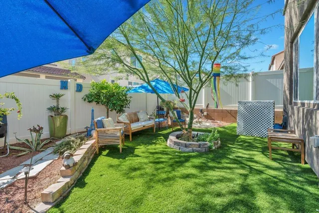 a view of a backyard with table and chairs under an umbrella