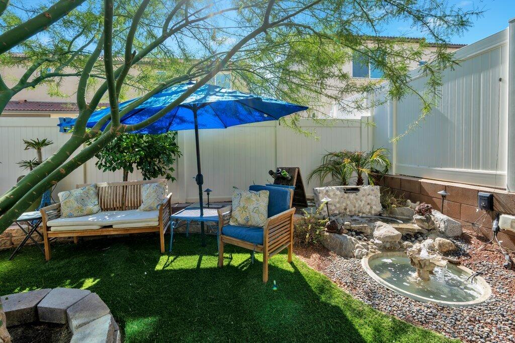 76345 Cornell Way Palm Desert, CA 92211 - Photo 31 of 47 a view of a backyard with table and chairs under an umbrella