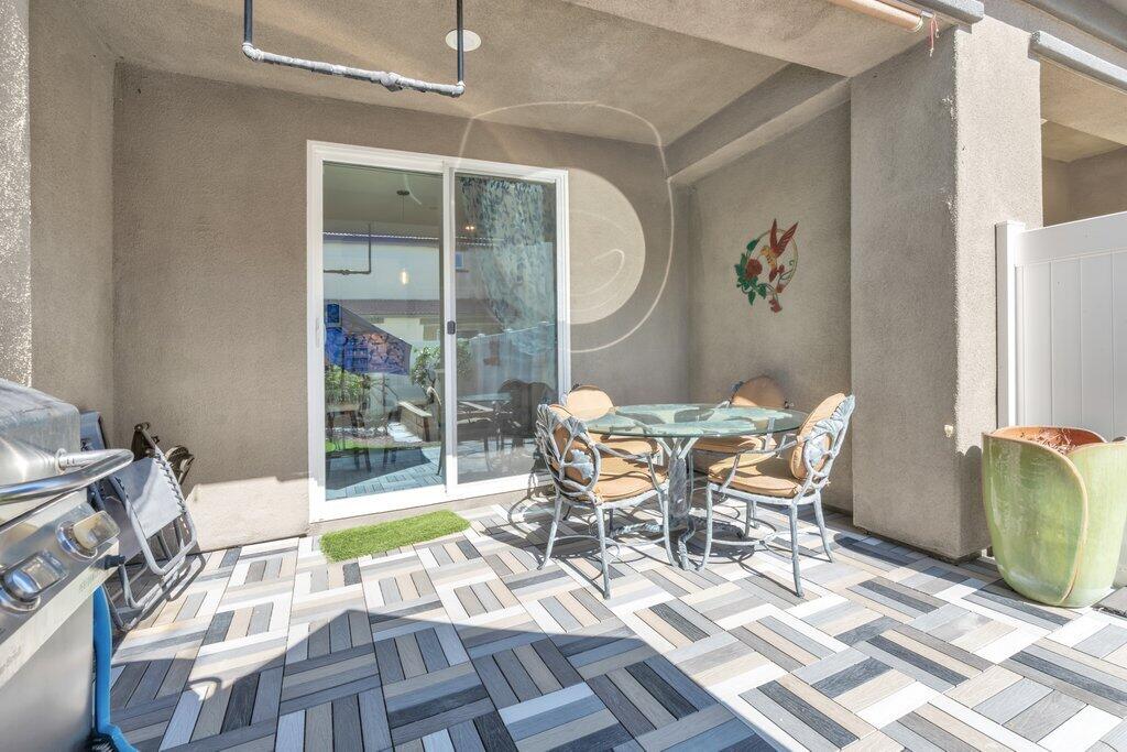 76345 Cornell Way Palm Desert, CA 92211 - Photo 35 of 47 a view of a dining room with furniture a chandelier and wooden floor