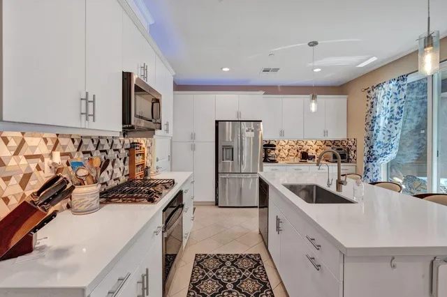 a kitchen with stainless steel appliances a sink stove and refrigerator
