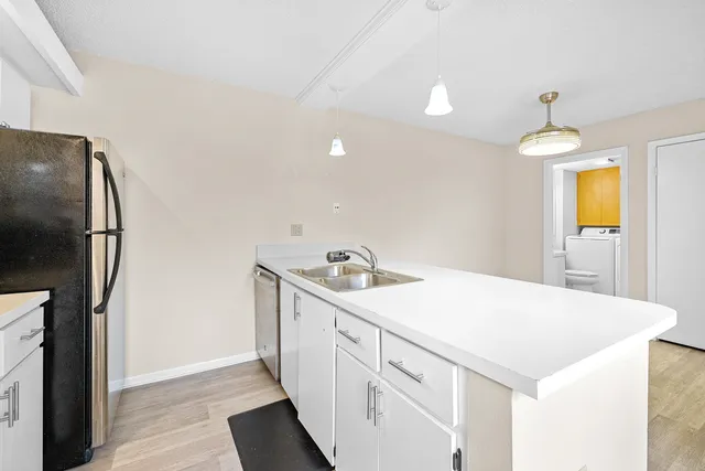 a kitchen that has a microwave a sink and a refrigerator