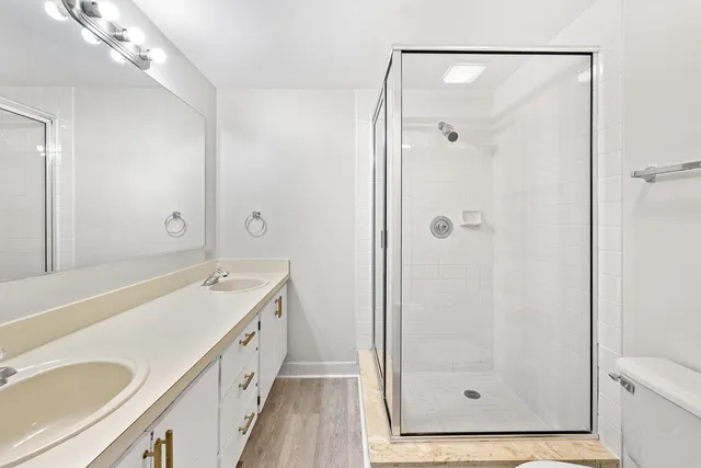a bathroom with a granite countertop sink a mirror a bathtub and shower