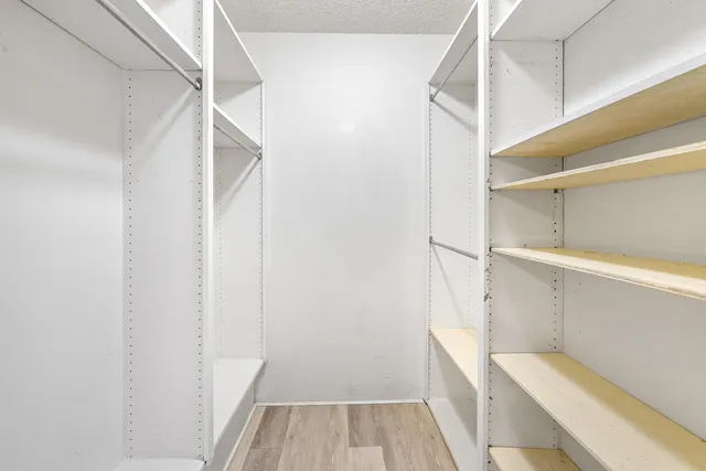 a view of walk in closet with empty racks