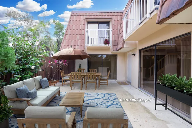 a view of a patio with table and chairs under an umbrella