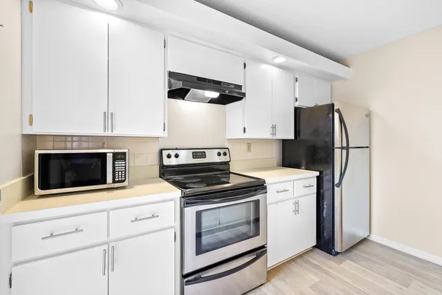 a kitchen with cabinets and steel stainless steel appliances