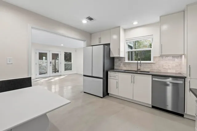 a kitchen with stainless steel appliances granite countertop a refrigerator sink and stove