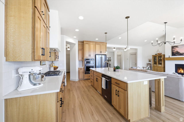 283 North 500 West Mapleton, UT 84664 - Photo 102 of 102 Kitchen with open floor plan, decorative backsplash, a large island with sink, light wood-style flooring, and a breakfast bar.