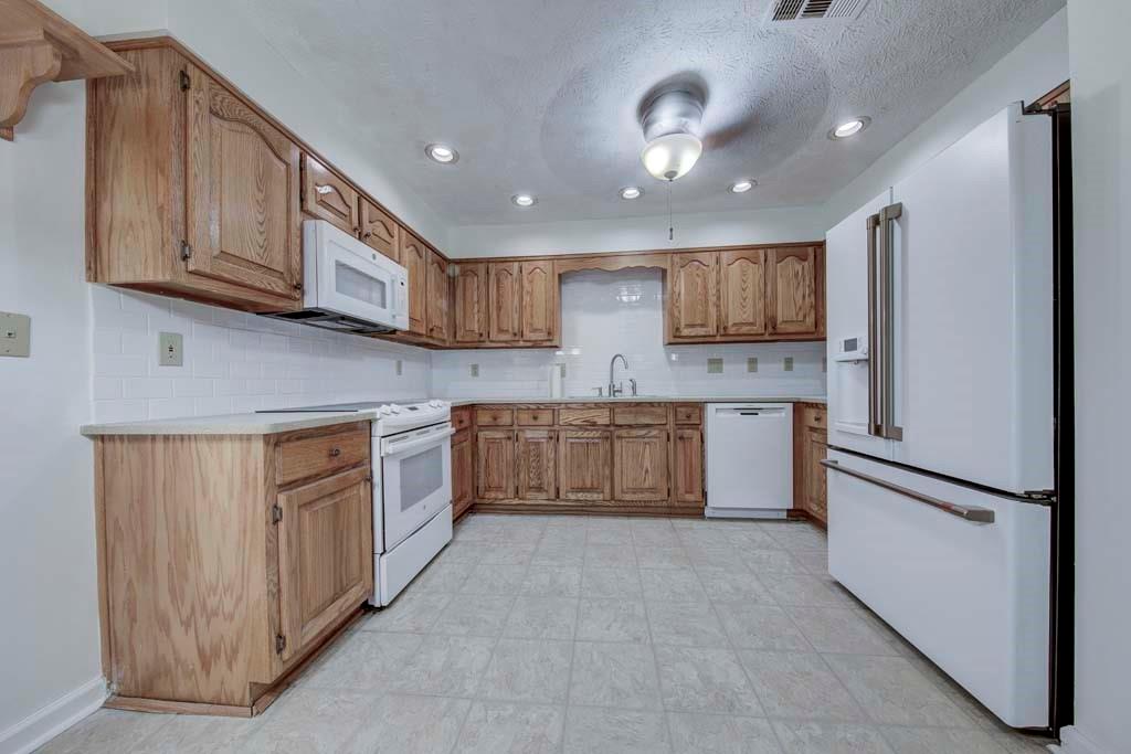 166 Maribeau Square Northwest Atlanta, GA 30327 - Photo 15 of 28 a large kitchen with stainless steel appliances granite countertop a stove a sink dishwasher and a refrigerator