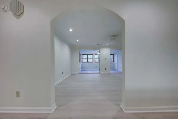a view of a big room with wooden cabinet and windows
