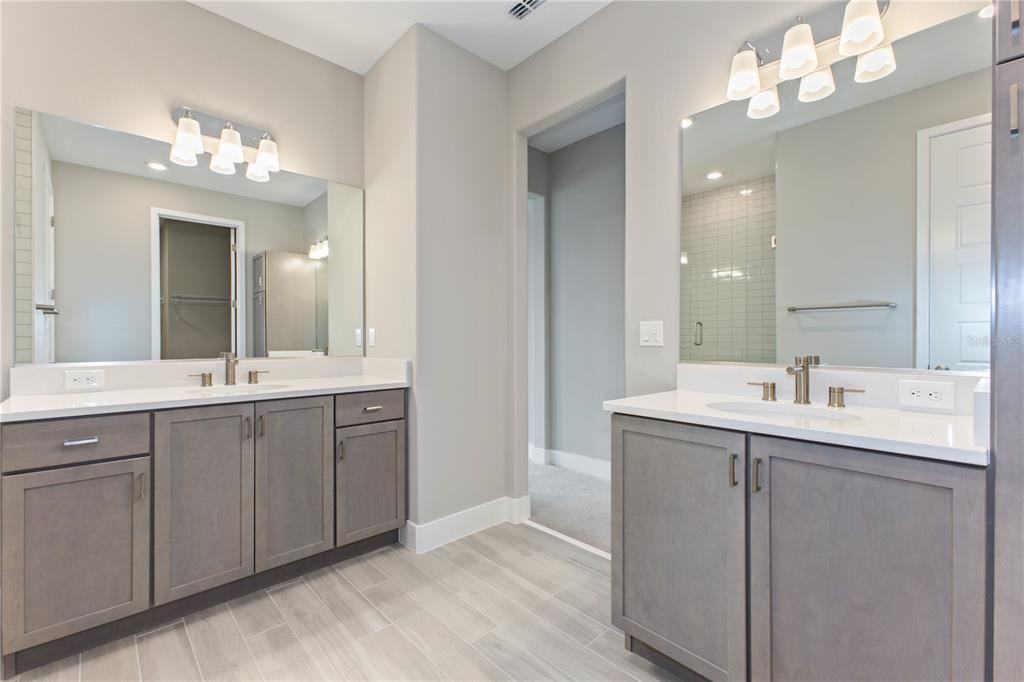 4516 Northwest 54th Terrace Ocala, FL 34482 - Photo 18 of 25 a bathroom with double vanity sink a vanity and a mirror