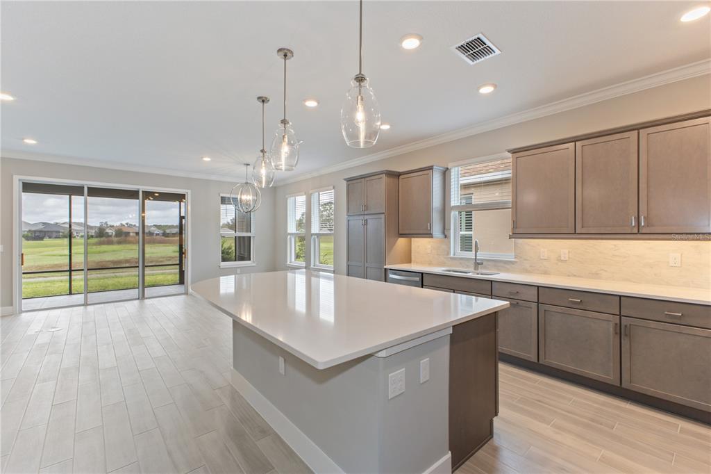 4516 Northwest 54th Terrace Ocala, FL 34482 - Photo 5 of 25 a large kitchen with kitchen island a large island wooden floor and stainless steel appliances