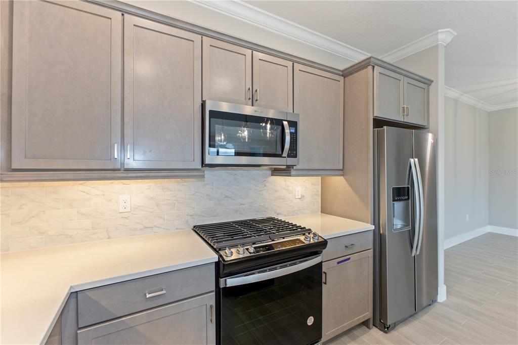 4516 Northwest 54th Terrace Ocala, FL 34482 - Photo 9 of 32 a kitchen with stainless steel appliances white cabinets and a stove top oven