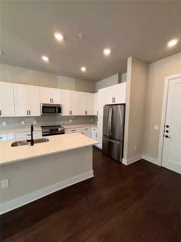 a large kitchen with stainless steel appliances a refrigerator and a stove top oven