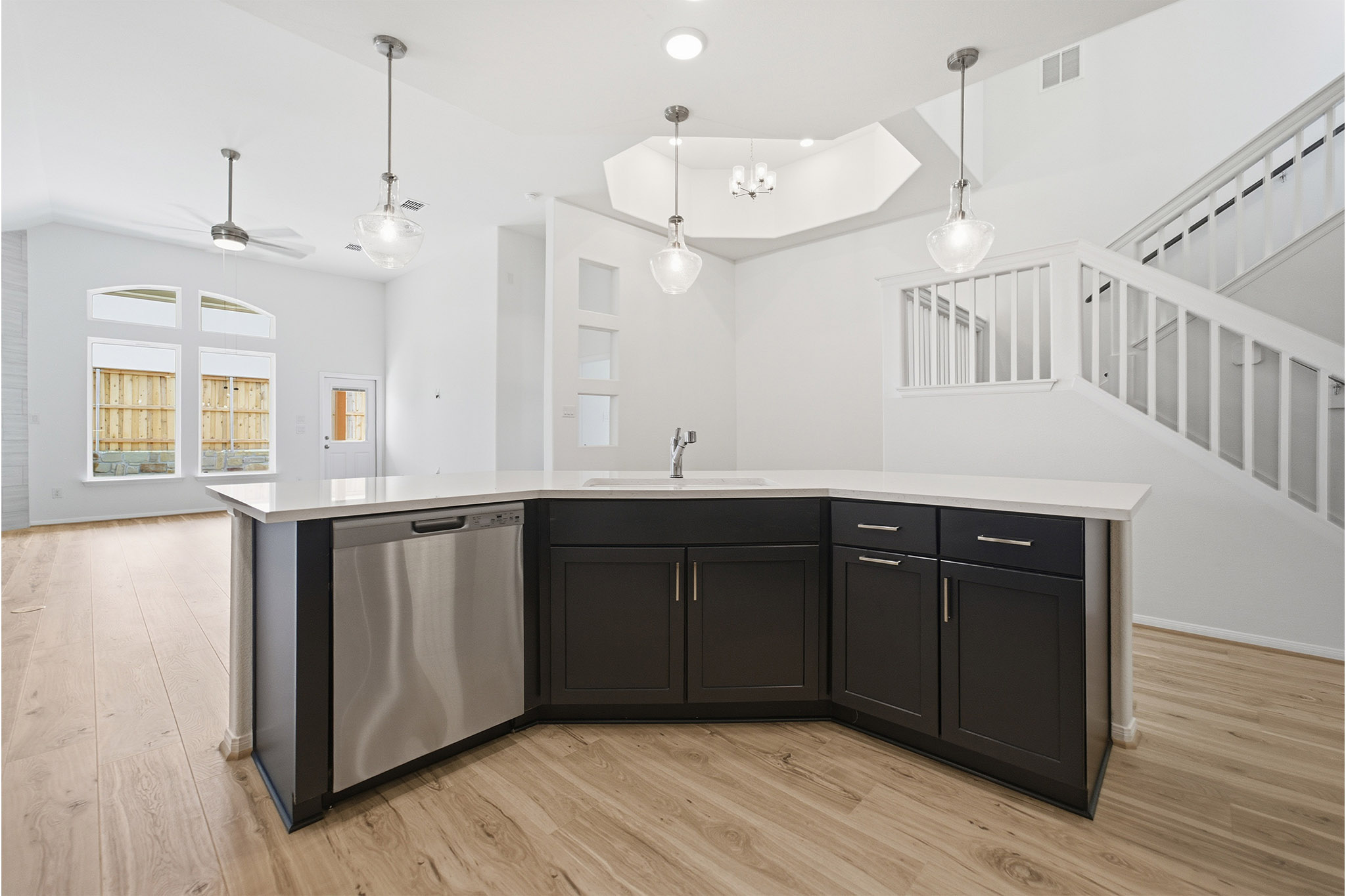 359 Grey Leaf Road Buda, TX 78610 - Photo 17 of 37 Kitchen with an island with sink, stainless steel dishwasher, light wood-style floors, and pendant lighting