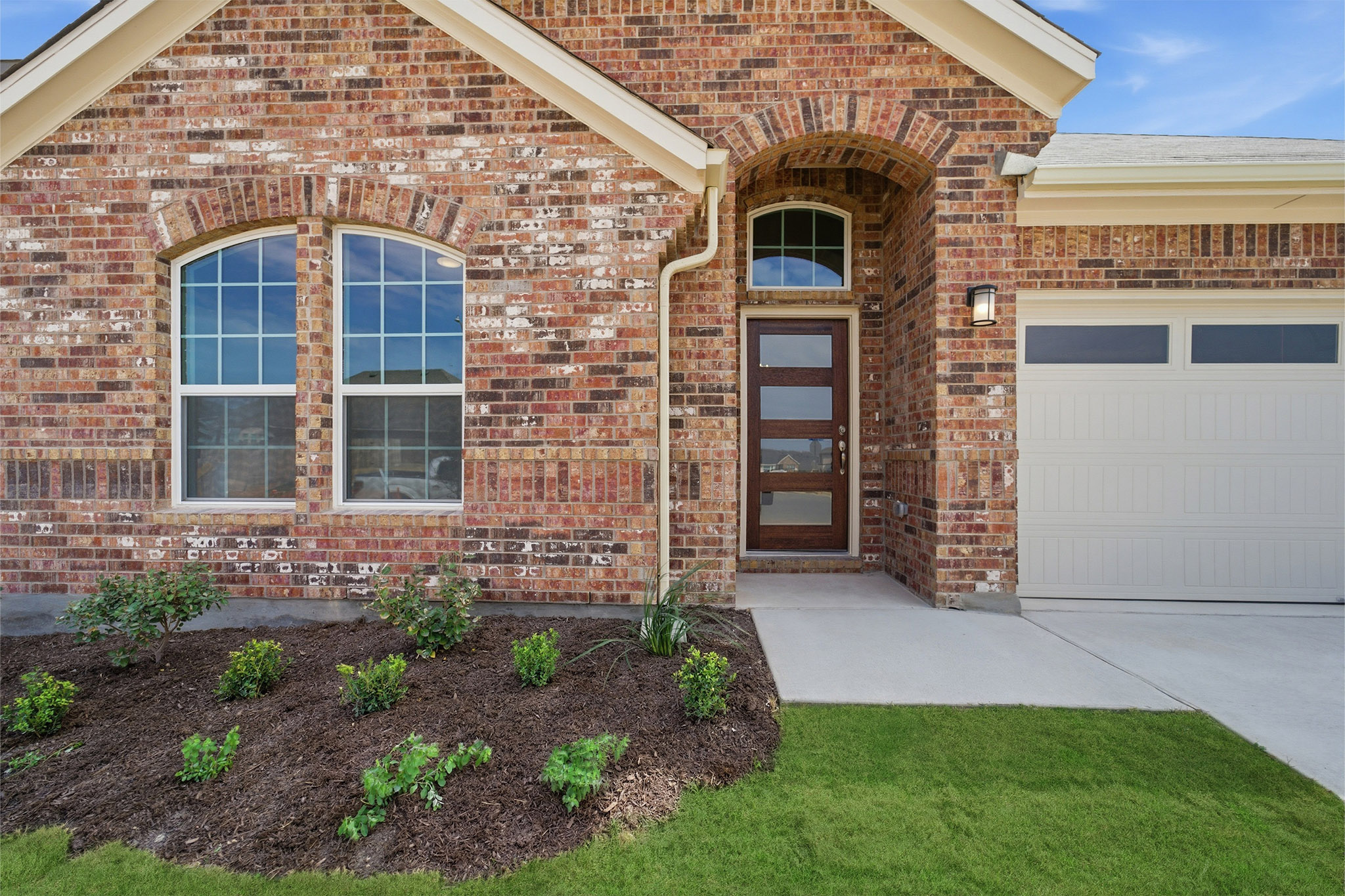 359 Grey Leaf Road Buda, TX 78610 - Photo 2 of 37 Doorway to property featuring brick siding, an attached garage, and driveway