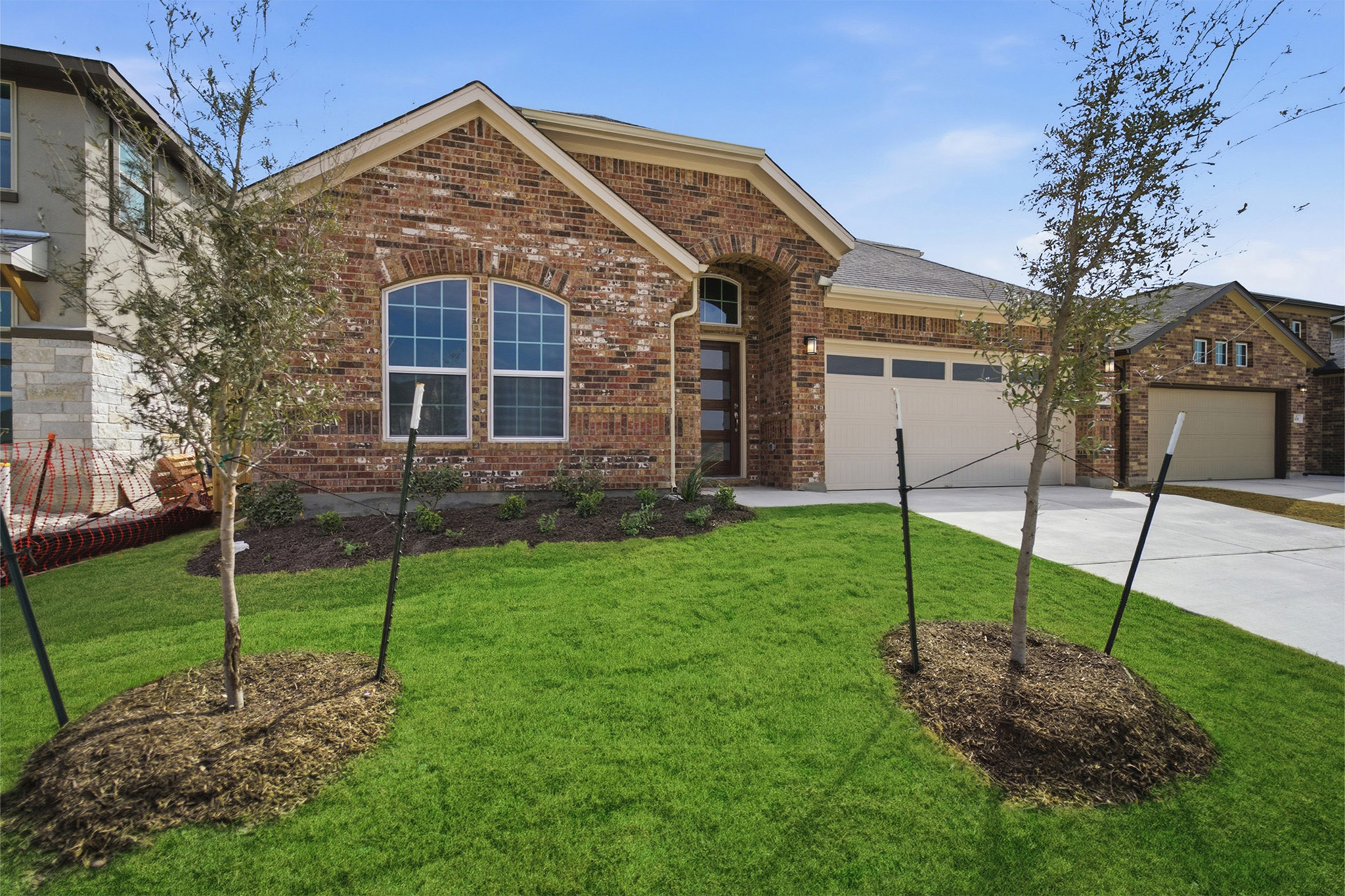 359 Grey Leaf Road Buda, TX 78610 - Photo 4 of 37 View of front of home with brick siding, driveway, a garage, and a front yard