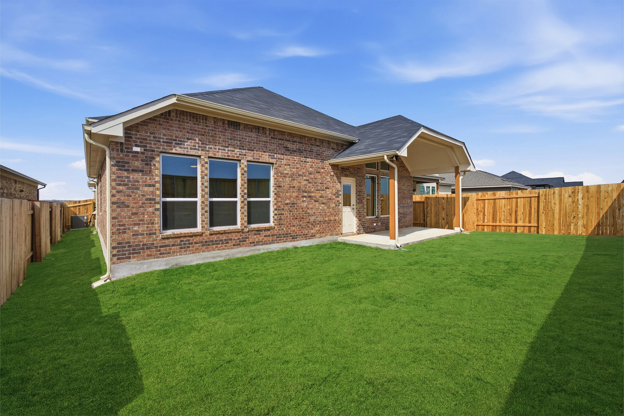 359 Grey Leaf Road Buda, TX 78610 - Photo 5 of 37 Rear view of house featuring a fenced backyard, a patio, brick siding, and a shingled roof