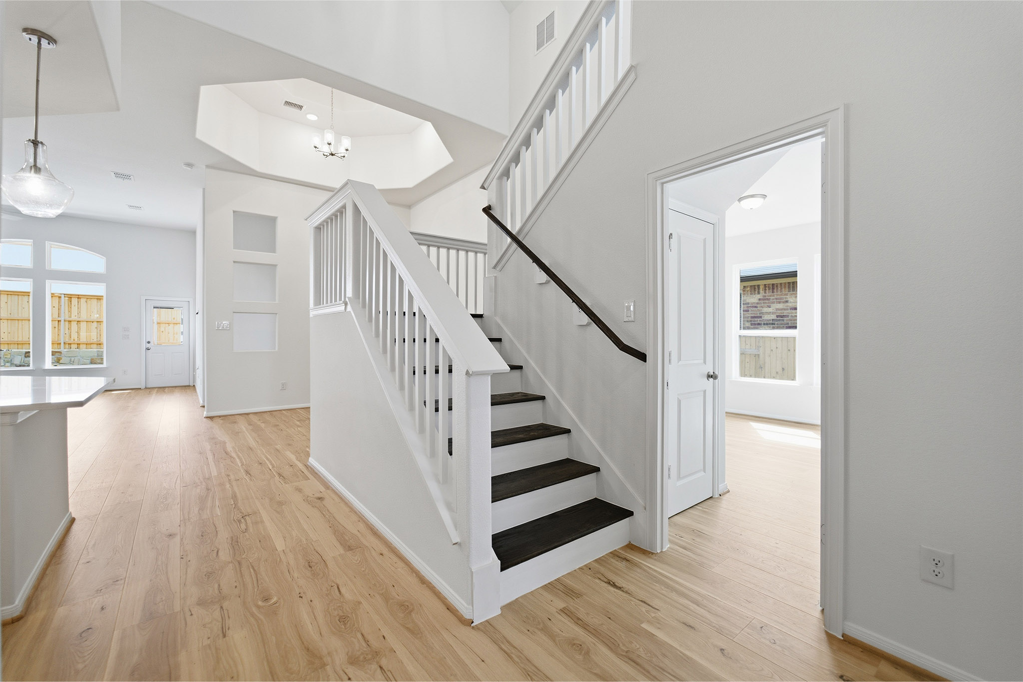 359 Grey Leaf Road Buda, TX 78610 - Photo 9 of 37 Stairs with wood finished floors, healthy amount of natural light, and a high ceiling