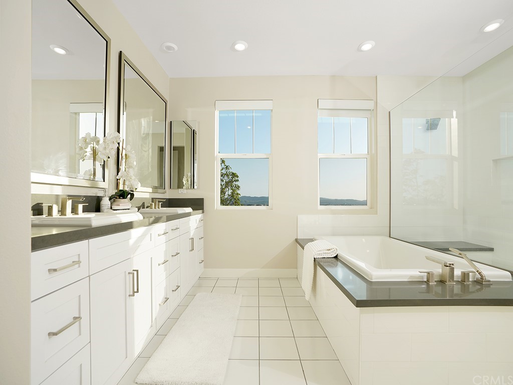 92 Iluna Irvine, CA 92618 - Photo 24 of 45 a bathroom with a granite countertop double vanity sink a mirror and a bathtub